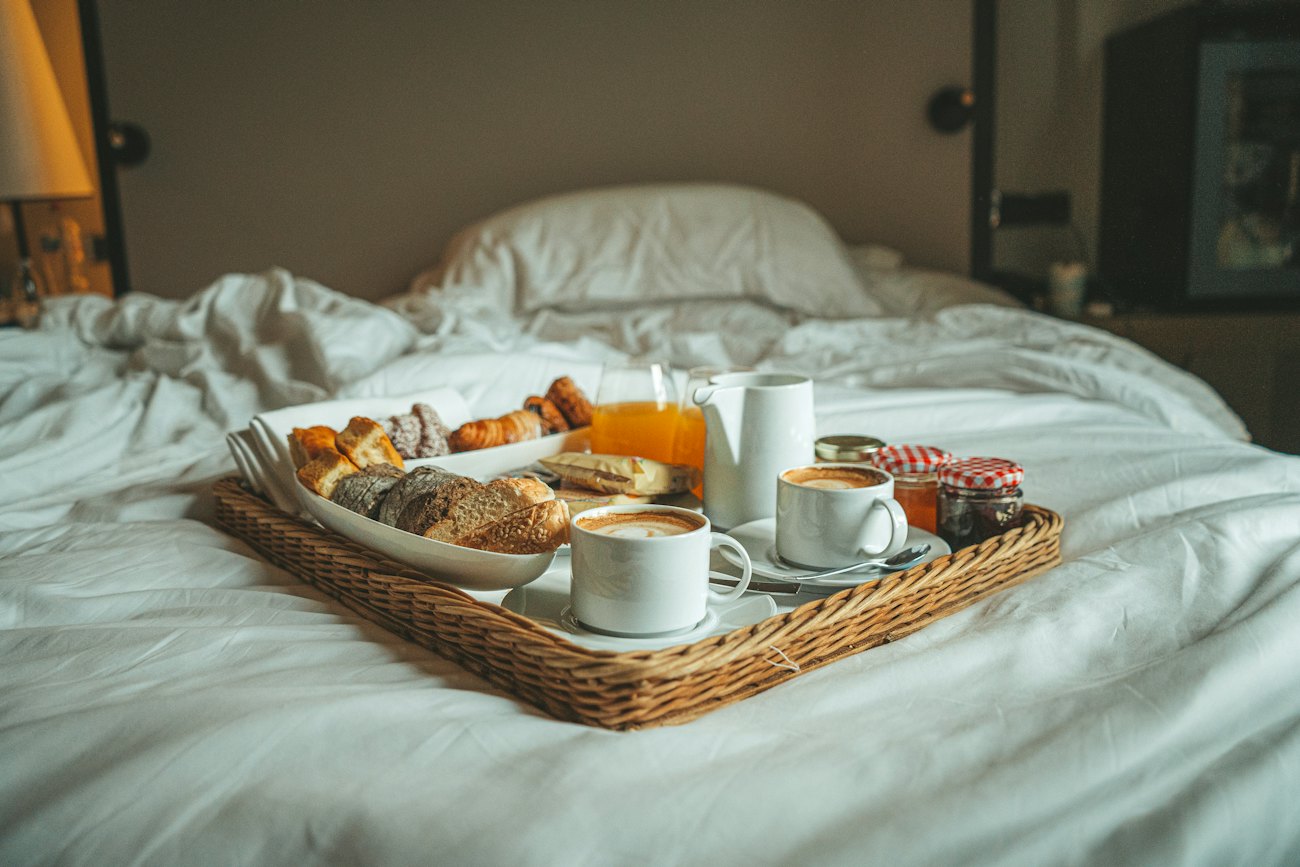 Breakfast tray on white bed linen