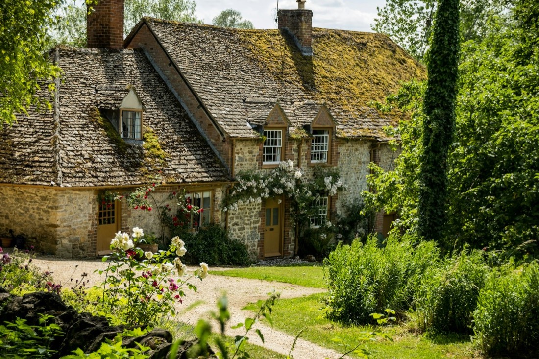 Honey-stone cottage in a green Cotswold garden